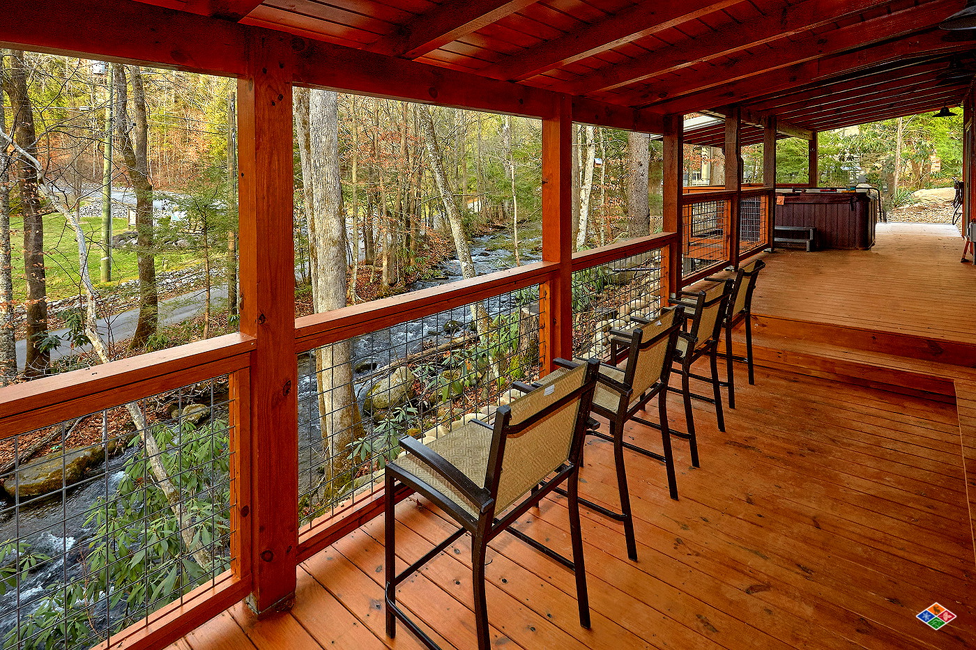 Covered creekside deck with seating at Talking Waters