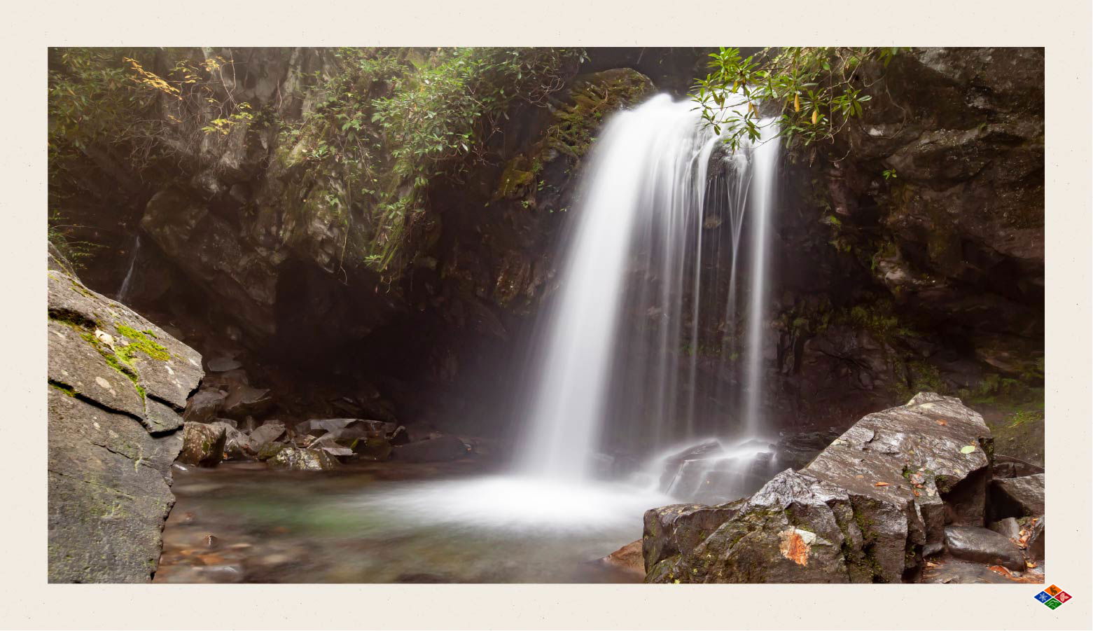 Waterfall pouring into a a basin surrounded by rocks