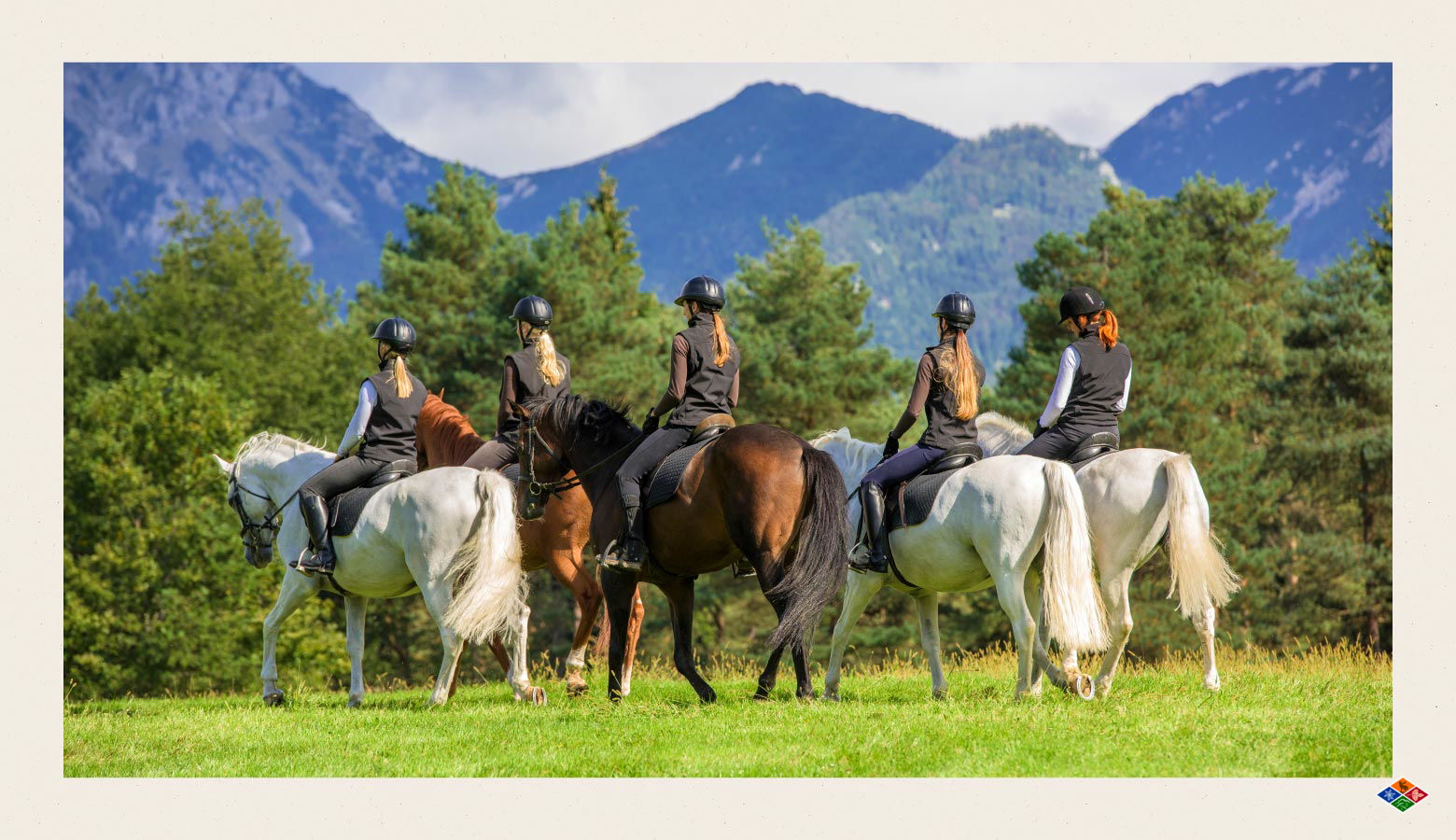 Five people riding horses with the Smoky Mountains in the background