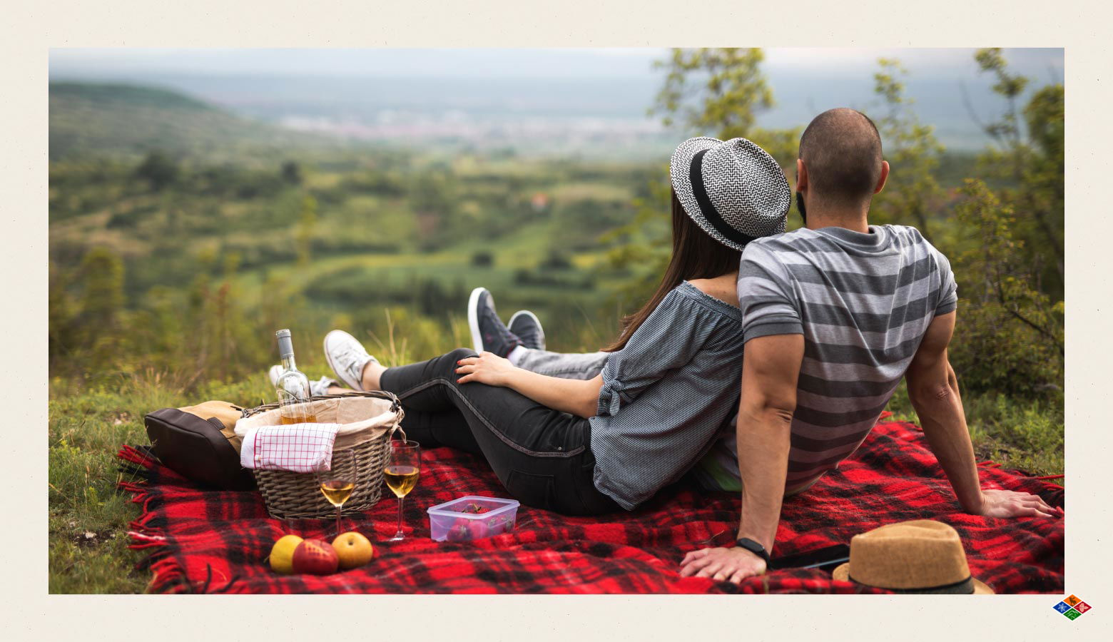 Summer picnic photo with a couple on a red and black plaid blanket overlooking the Smoky Mountains