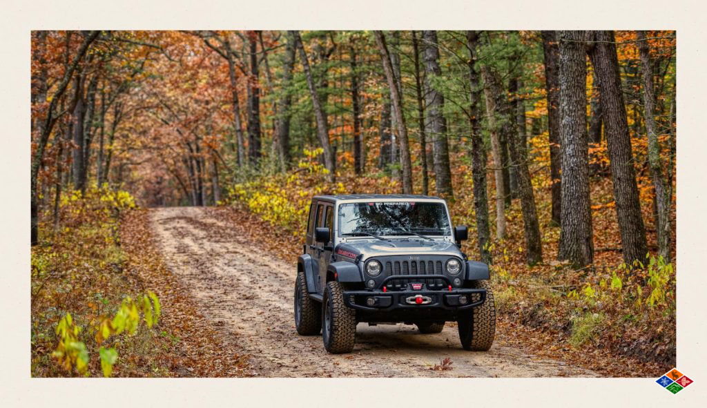 A family drives their jeep rental through the woods to a hiking trail in Gatlinburg. 