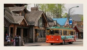 The orange and green Gatlinburg Trolley picks up passengers on its route. 