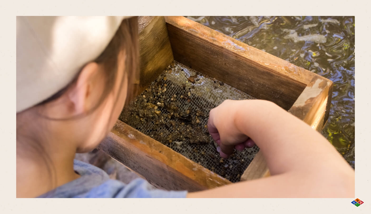 A child mines for gems by sifting away the dirt. 