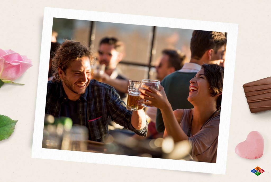 People on a date laugh together over a couple of beers.