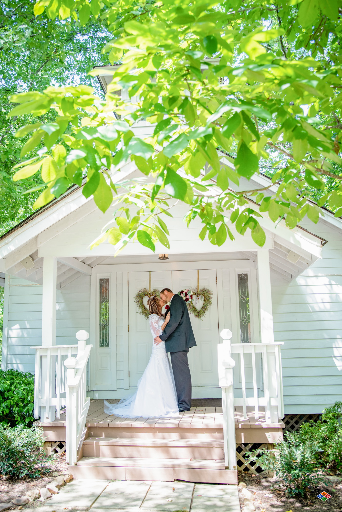 Bride and groom outside the white wedding chapel at Bluff Mountain Inn