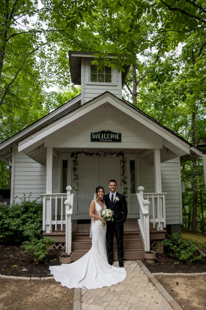 Newly married couple on the steps of the white chapel at Bluff Mountain Inn
