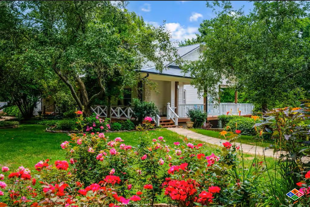 Rose gardens in bloom along the porch at Bluff Mountain Inn