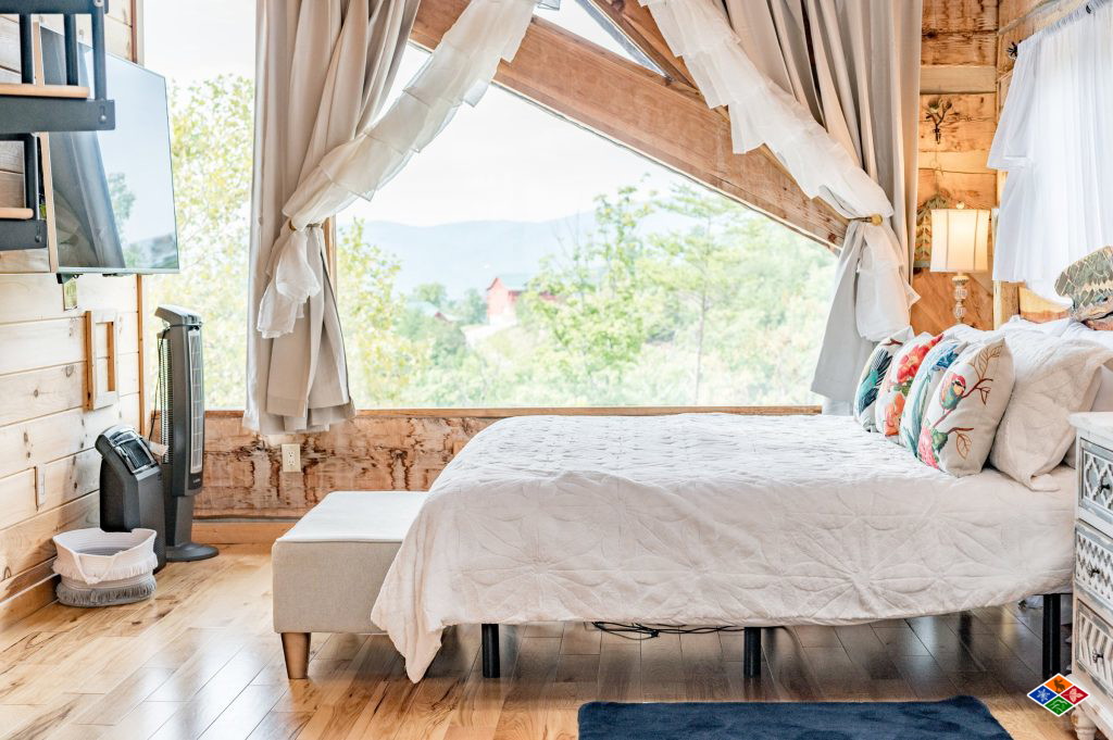 A bedroom at Cielito Lindo with a wall of windows looking out over the mountains