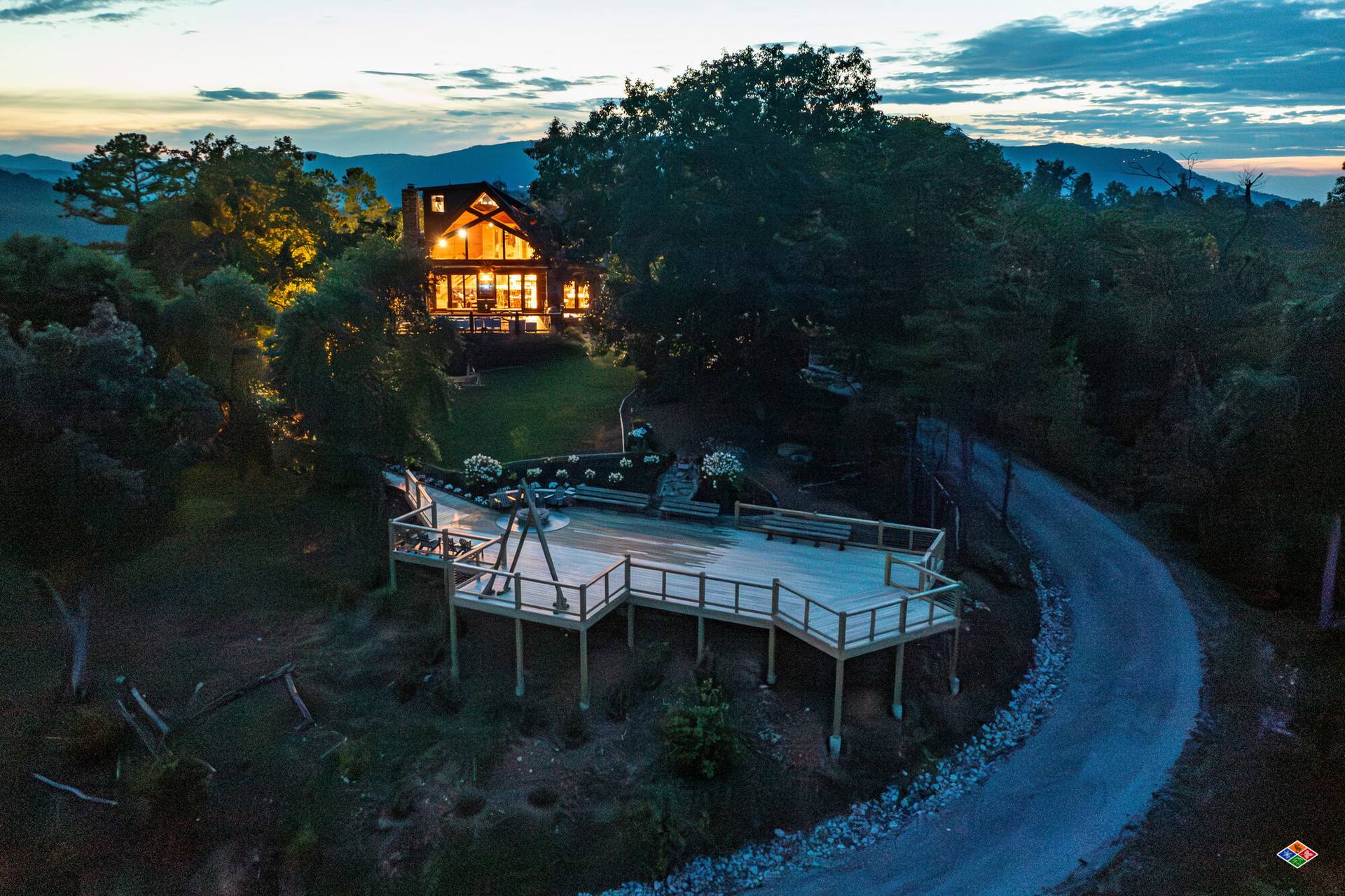 Aerial view at twilight of Cielito Lindo lit up on its mountaintop with the separate ceremony deck below, overlooking the Smoky Mountains