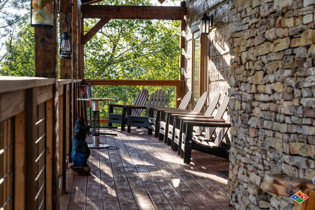 Row of Adirondack chairs along the covered deck at Cielito Lindo beside the stone chimney