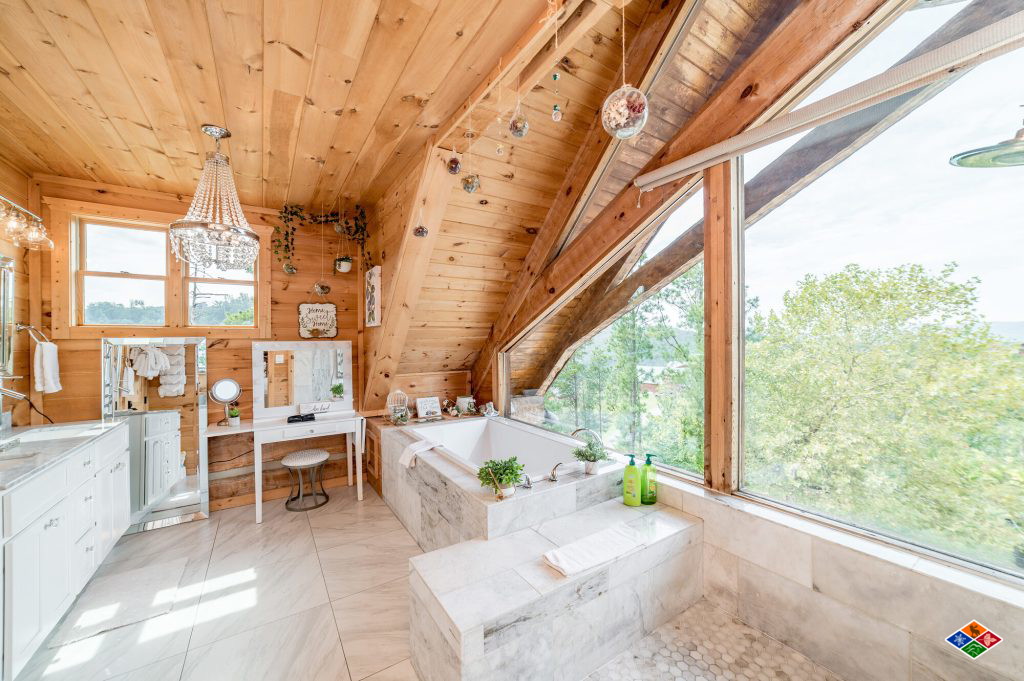 Master bath at Cielito Lindo with a freestanding soaking tub, chandelier and a wall of windows