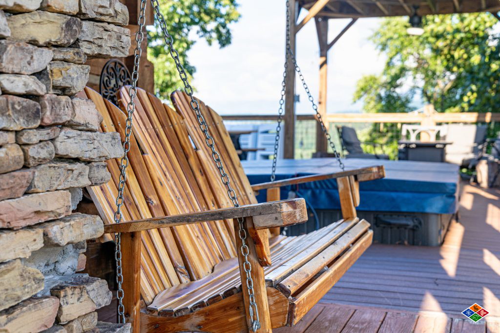 Cedar porch swing beside the private hot tub on the covered deck at Cielito Lindo