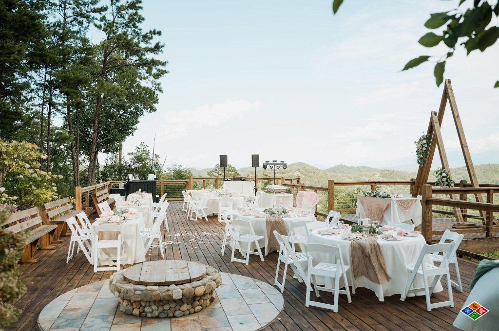 Reception tables set on the Cielito Lindo deck around the stone fire pit, with the mountains beyond