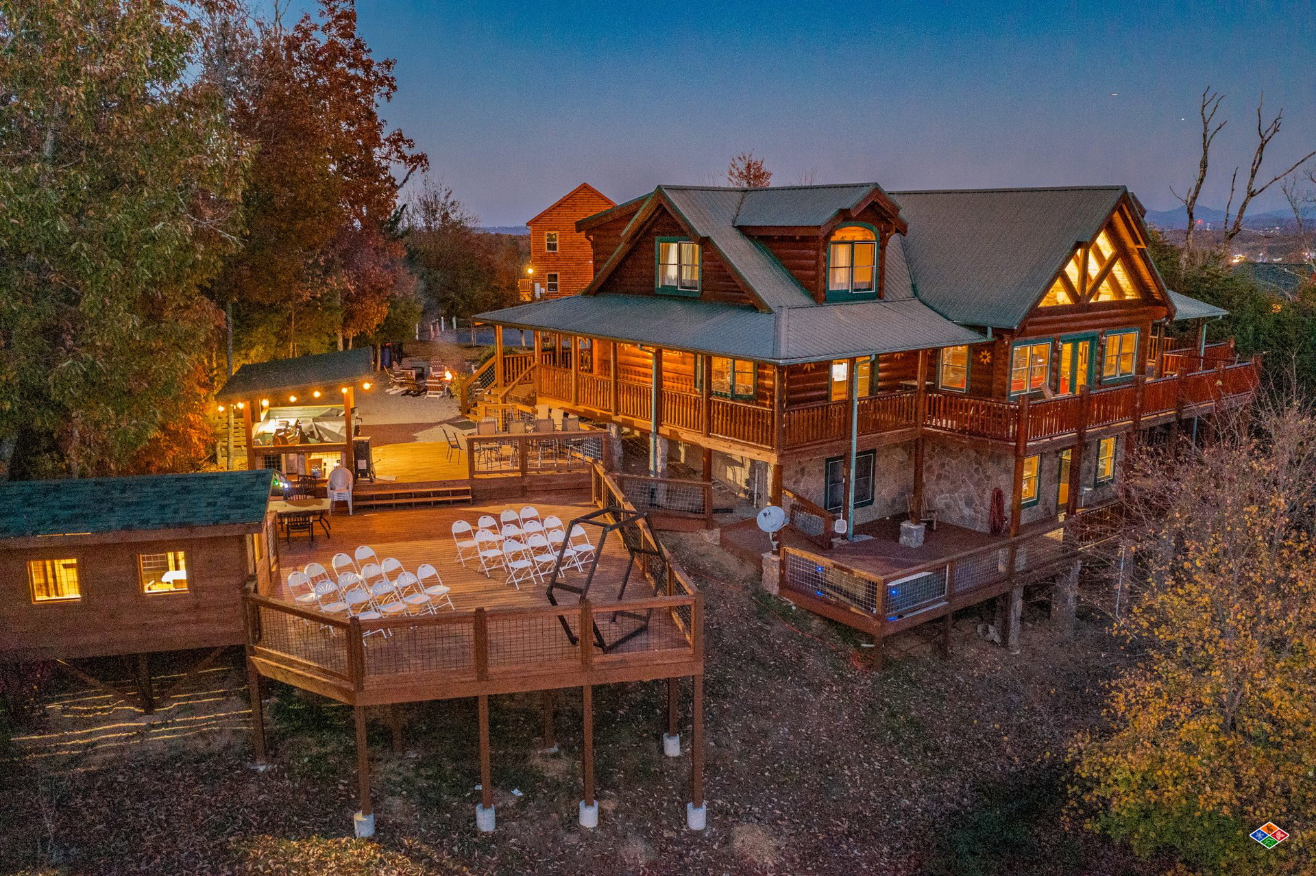 Big Kahuna Smoky Mountain wedding and event cabin at dusk with ceremony chairs set up on the deck
