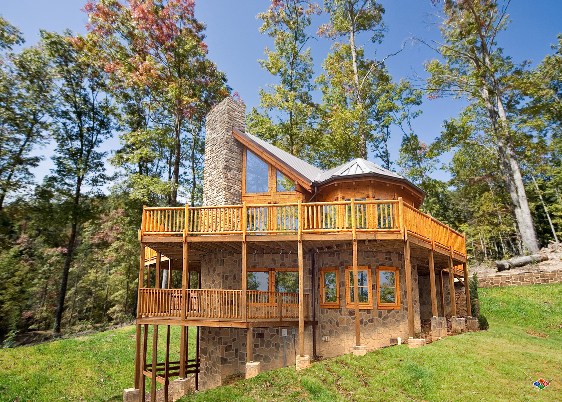 Exterior of Silvercreek, a three-level log home with stone chimney and wrap-around decks